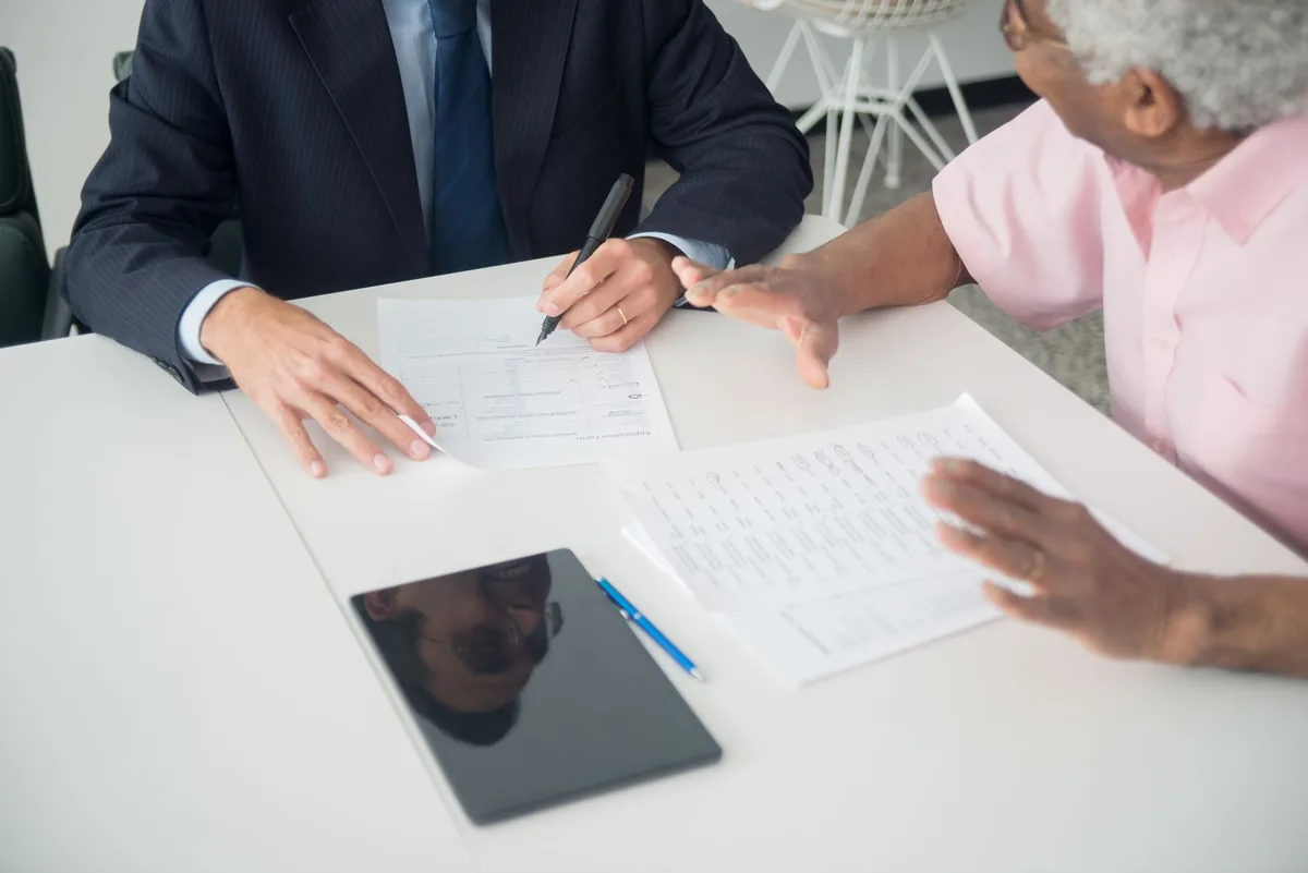 Consultor e cliente revisando documentos em reunião